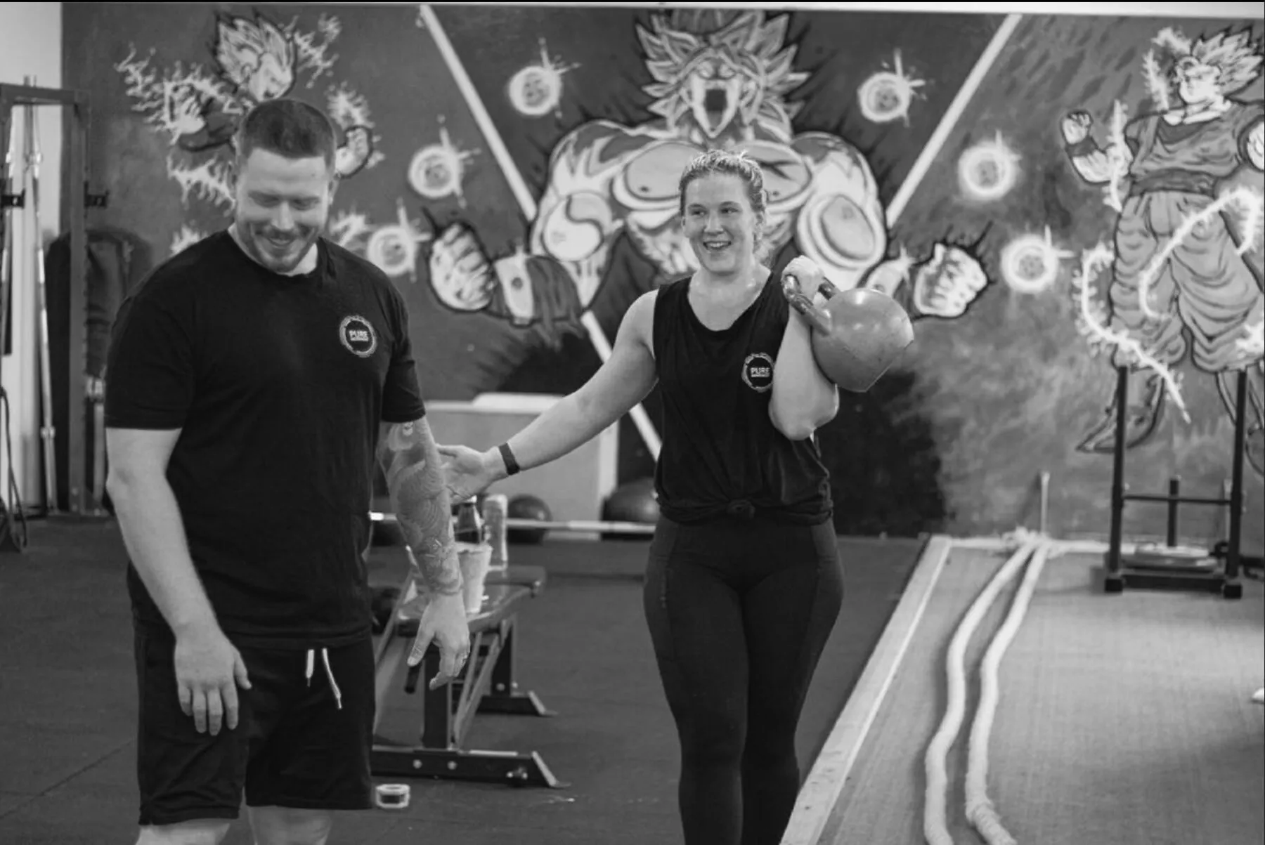 A trainer and client sharing a laugh between sets at PURE Movement.